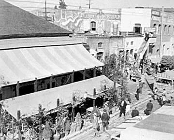 In this 1933 photograph of Olvera Street, the whitewashed Siqueiros mural América Tropical, can be seen in the upper right half of the photo. The authorities whitewashed the part of the mural that could be seen from the street – which is seen here as a large blank space. City authorities later obliterated the entire mural with whitewash. Photo/Los Angeles Times archives.