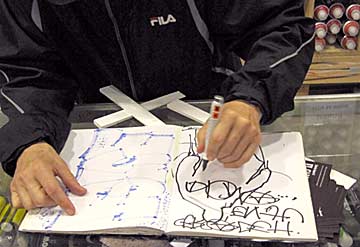 The Phantom autographs the sketch book of a young fan with his signature placa on the opening night of "By The Time I Get To Arizona." Phantom’s graffiti body outlines with politicized text have long appeared on L.A. streets, one such image appeared as cover art for "The Battle of Los Angeles," the third studio album by Rage Against the Machine. Photo/Vallen ©