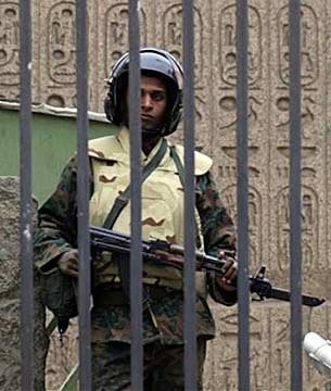 AP photograph A soldier cradling an AK-47 automatic rifle with a fixed bayonet, stands behind the locked gates of the Egyptian Museum. AP Photo.