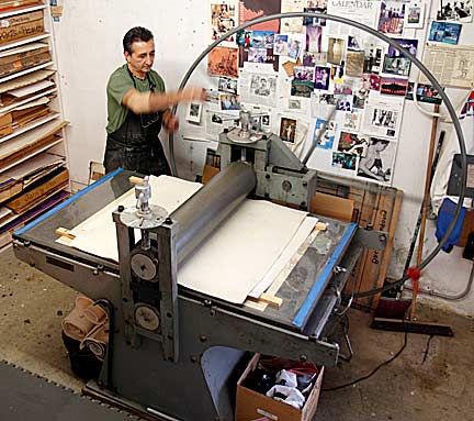 Greco turns the wheel of his large American French intaglio press to print the block. Photograph by Mark Vallen ©