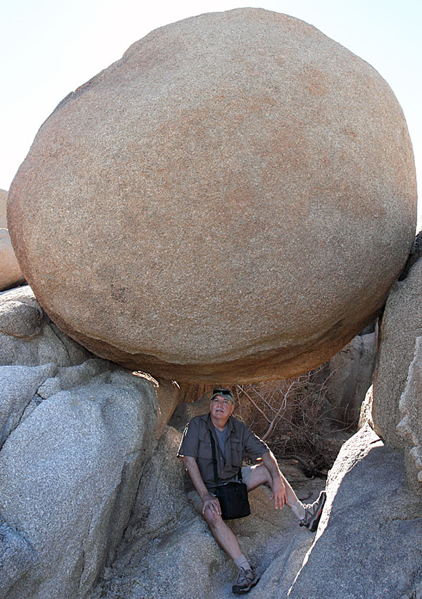 [The artist with his "Alleviated Masses" 100-ton boulder at a secret desert location storage area. Photograph by Jeannine Thorpe © ]