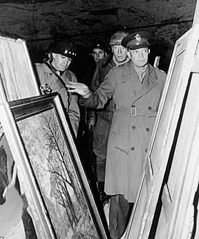 In this photo, U.S. Generals Eisenhower (right), Patton (middle), and Bradley (left), inspect some of the looted paintings hidden by the Nazis at the Merkers salt mine in Thuringia, Germany. Photo courtesy of The U.S. National Archives and Records Administration. 