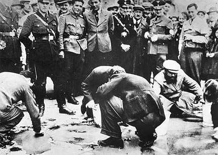 This photo taken by an anonymous photographer during the opening days of the Nazi annexation of Austria shows Nazi collaborators humiliating Jews by having them scrub sidewalks in Vienna. Photo from the U. S. Holocaust Memorial Museum, courtesy of the U.S. National Archives and Records Administration.