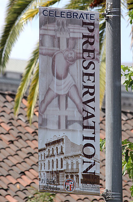 Banner featuring the central motif of the América Tropical mural, posted by the City of Los Angeles on Main Street adjacent to Olvera Street. Photograph by Mark Vallen ©.