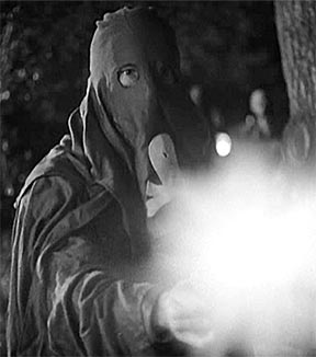 Still from Black Legion. In this photo Bogart, as a hooded Black Legion terrorist, shoots and kills one of the group's opponents.