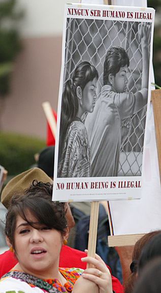 "Ningun ser Humano es Ilegal" (No Human Being is Illegal). Mark Vallen. Offset poster ©. This photo shows the poster carried at the 2010 Chicano Moratorium march in Los Angeles, CA.