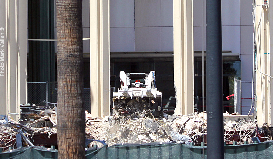 "Dragon Lair." Like a dragon coming out of its lair, a bulldozer pops out of the Los Angeles County Museum of Art, to dump the guts of the museum in a pit of rubble. But in this tale there’s no Saint George to slay the beast. Photo Mark Vallen ©. May 14 2020.