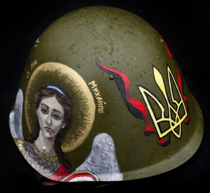 Helmet. Photo by Tom Jamieson. 2014 ©. Worn by a Maidan street fighter, this army helmet is painted with an image of St. Michael and the trident crest of Ukraine. But it also displays the red and black colors of Stepan Bandera's Nazi backed Ukrainian Insurgent Army. An online portfolio of Jamieson's photos can be seen at: www.tom-jamieson.com/portfolio/projects/weapons-of-maidan 