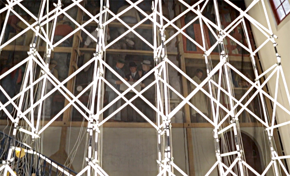 "Pereda thinks his scaffold provides a different screen with which to see the world through. The luminous glow from the fluorescent bulbs makes it impossible to view or photograph Rivera's fresco!" Screen grab from the SFIA short film, "Change the World or Go Home."