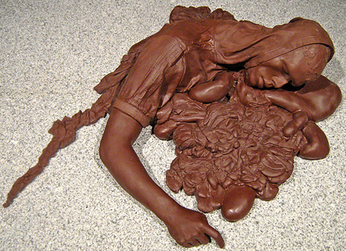 "On the road to Heaven the Highway to Hell." Sculpture cast in dark chocolate depicting remains of a suicide bomber.